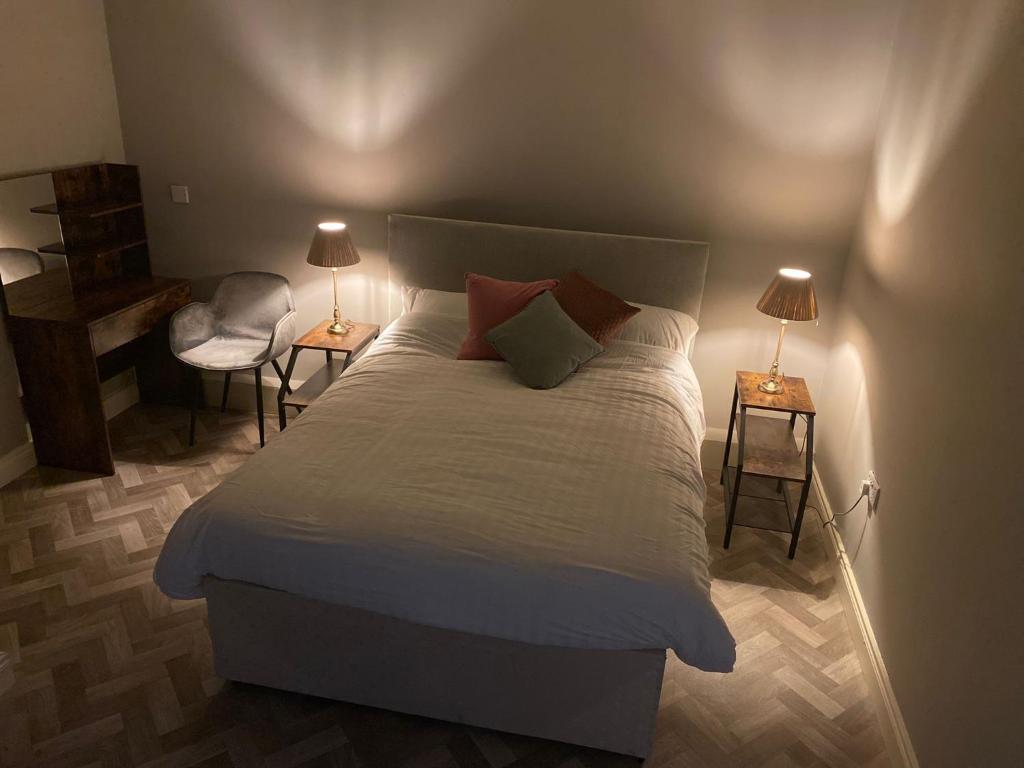 卡洛The Corner Apartment的一间卧室配有一张床、一把椅子和两盏灯。