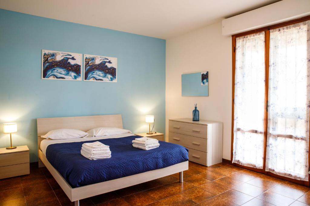 比萨Etruria Airport的蓝色的卧室设有床和窗户