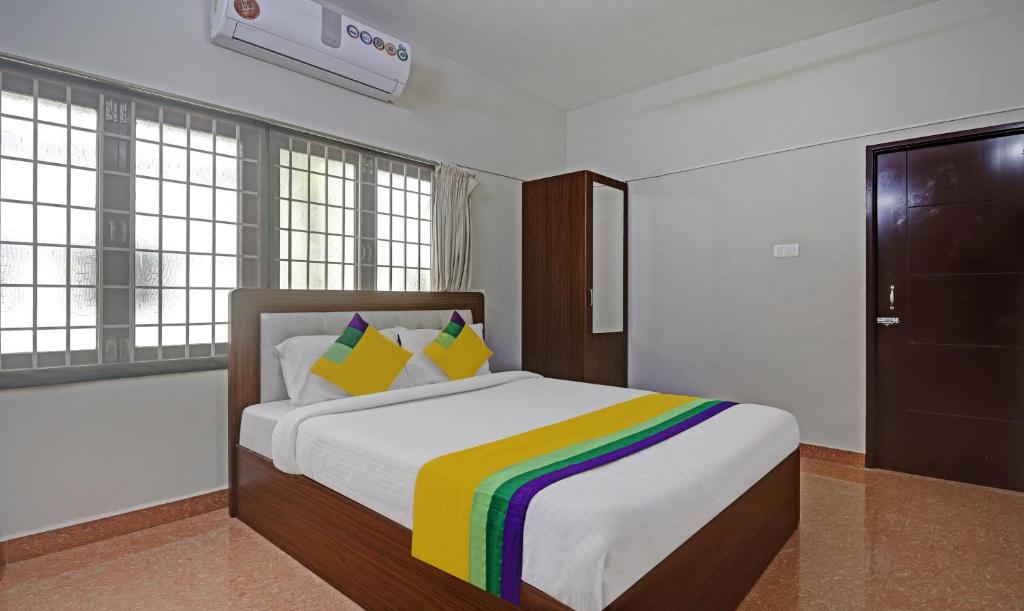 钦奈Itsy Hotels Rithika Inn Blossoms的一间卧室配有一张带彩虹毯子的床