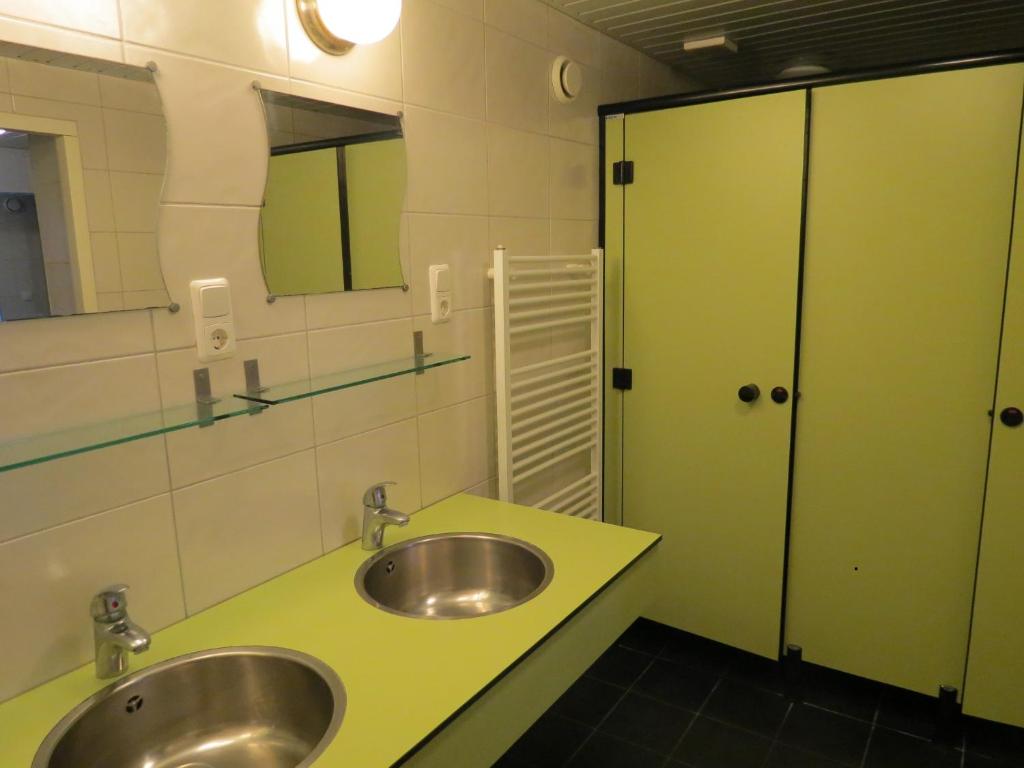 RuinenSafaritent de Berghoeve的浴室设有两个盥洗盆和一个绿色的柜台。