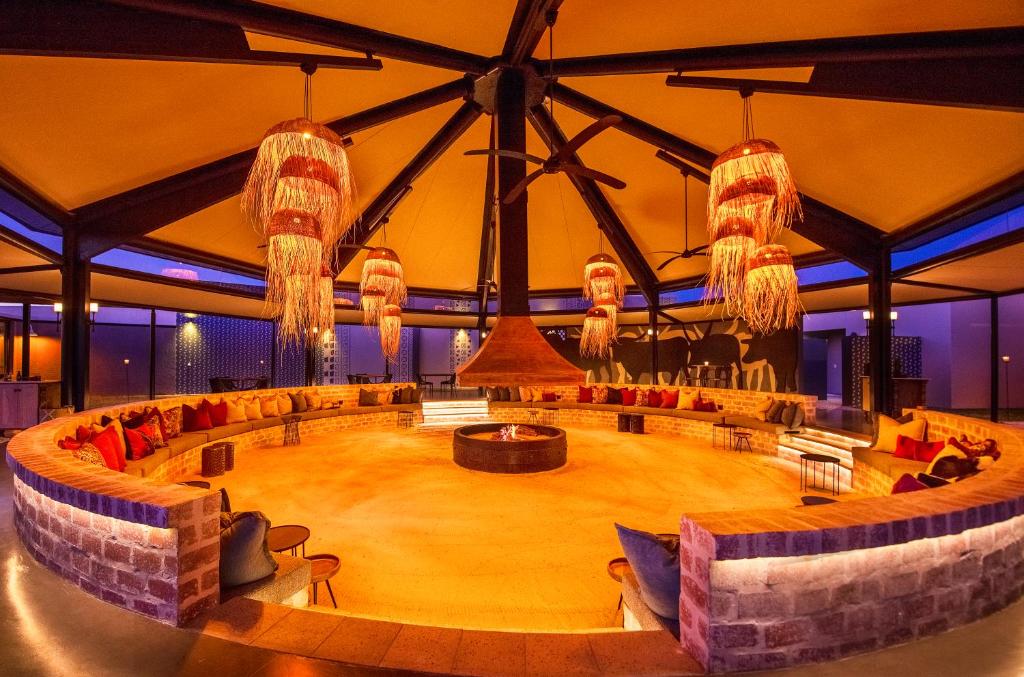 OmuthiyaEtosha King Nehale的大房间设有舞台,配有沙发和吊灯