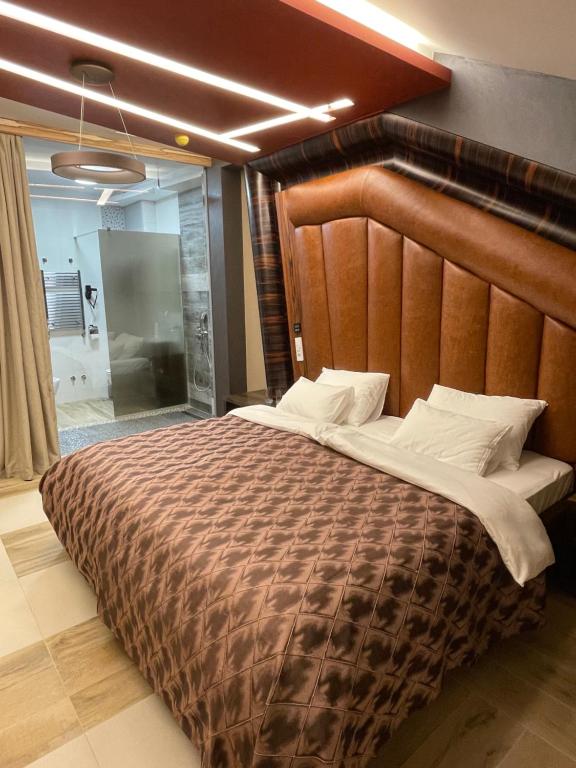 洛兹尼察Hotel Havana Loznica的卧室里有一张带木质床头板的大床