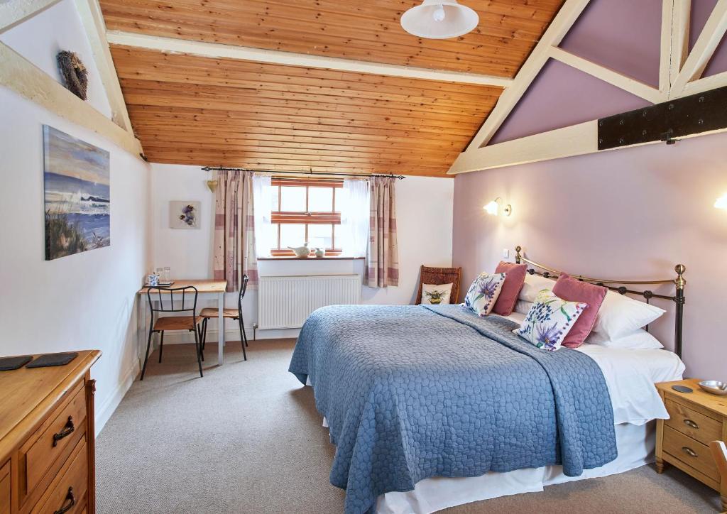 HicklingDairy Barns的一间卧室设有一张床和木制天花板