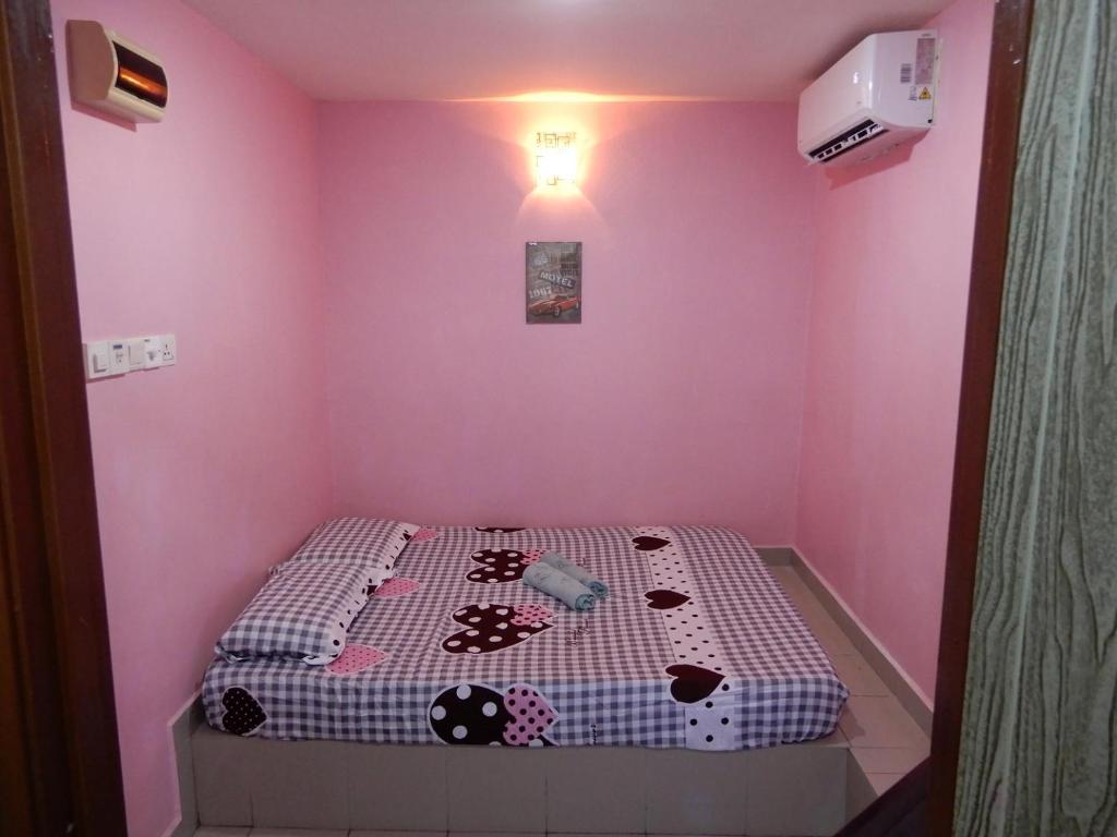 双溪大年LA MOTEL的一间小卧室,卧室内配有一张位于粉红色客房内的床铺