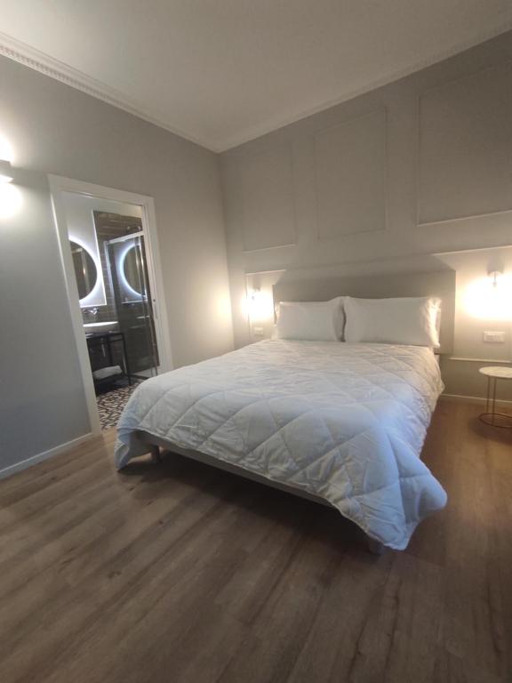 安科纳Residenza Montebello的一间卧室配有一张带两盏灯的大型白色床。