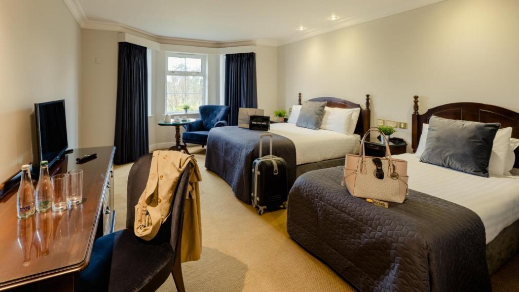 巴利纳双树休闲俱乐部酒店的酒店客房设有两张床和电视。