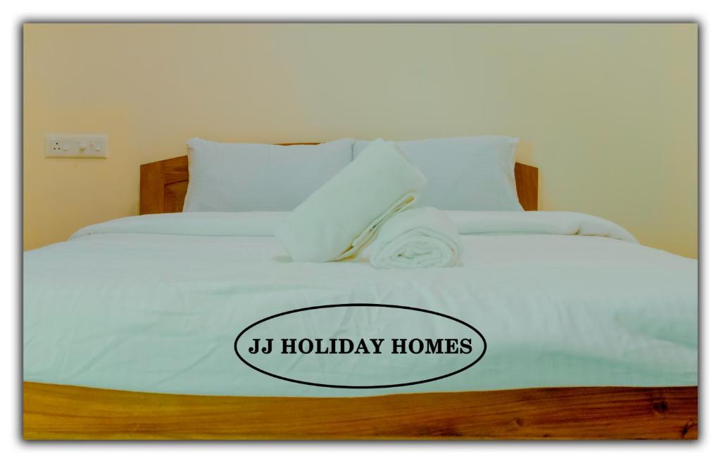CanaguinimJJ Holiday Homes的一张带阅读度假屋标志的白色床