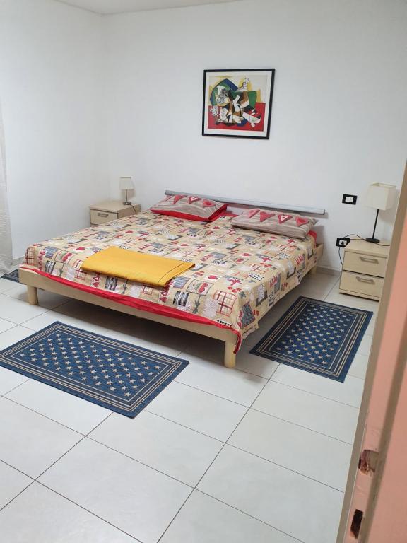 勒威诺Villa Monica的卧室配有一张床,地板上设有两张垫子