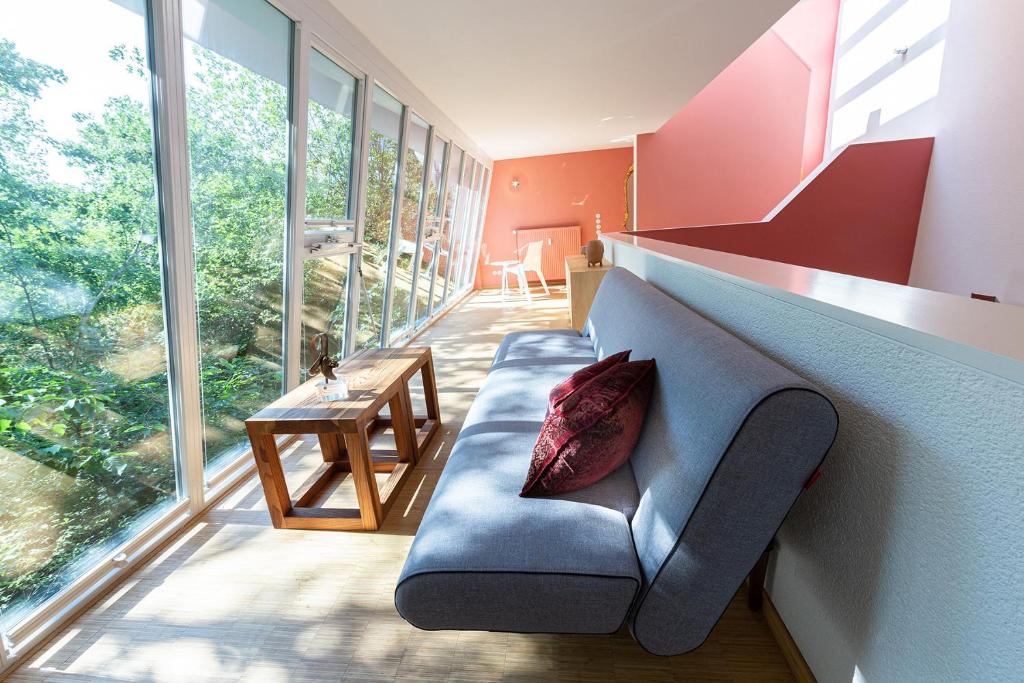 达姆施塔特Darmstadt Loft的客厅设有蓝色的沙发和大窗户