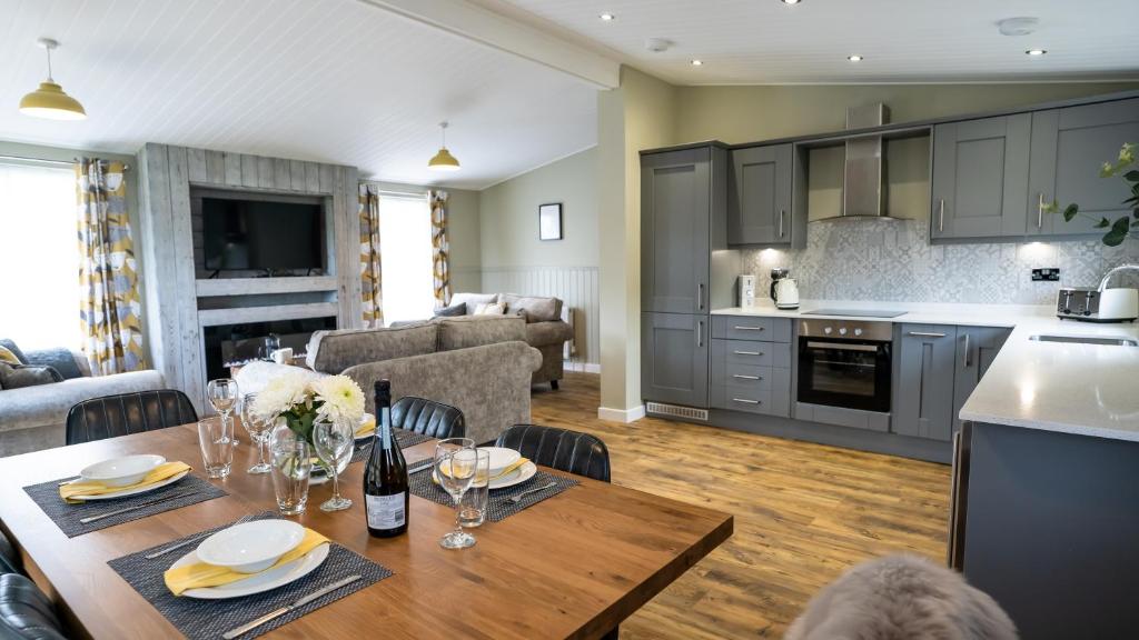 SidleyChestnut Meadow Country Park的厨房以及带木桌和椅子的客厅。