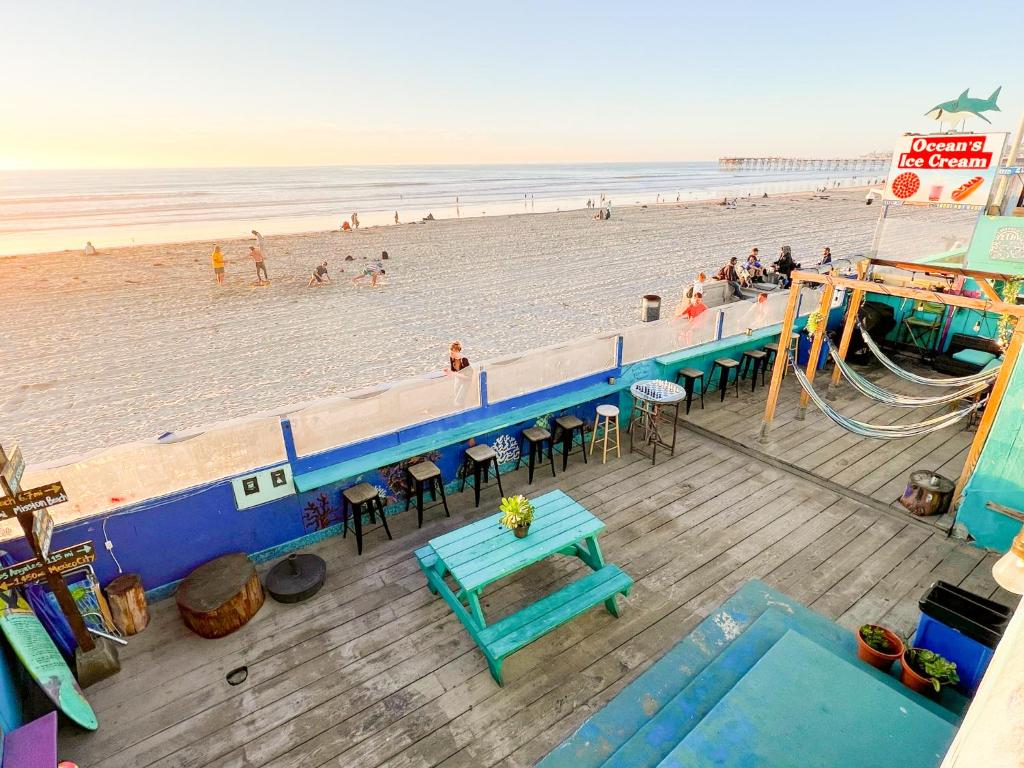 圣地亚哥圣地亚哥ITH海滩简易别墅冲浪旅舍的海滩上方的蓝色桌子和长椅
