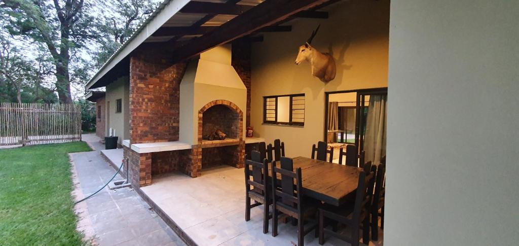 赫卢赫卢韦Honeybird self catering Accommodation的庭院设有木桌和壁炉。