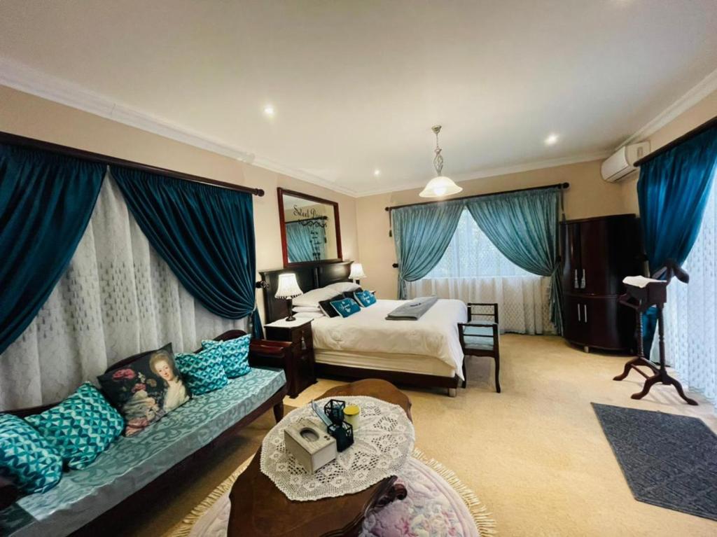 绍斯布鲁姆Casa Alegre Guesthouse的一间卧室配有一张床和一个沙发