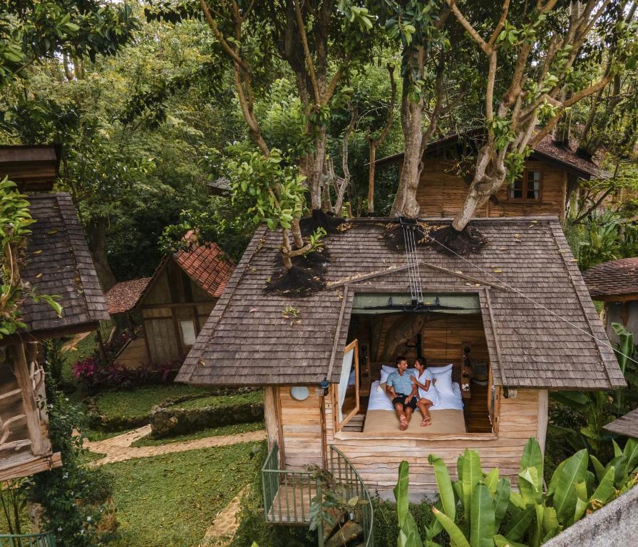 乌鲁瓦图Roots Tree House的坐在树屋床边的一对夫妇