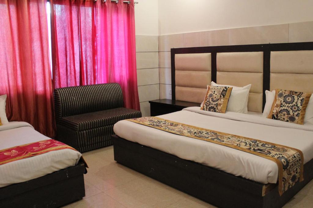 格德拉Trimrooms JMC Katra Railway Road的酒店客房,配有两张床和椅子