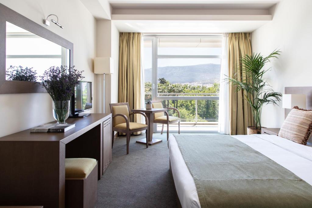 雅典Amalia Hotel Athens的酒店客房设有一张床和一个大窗户