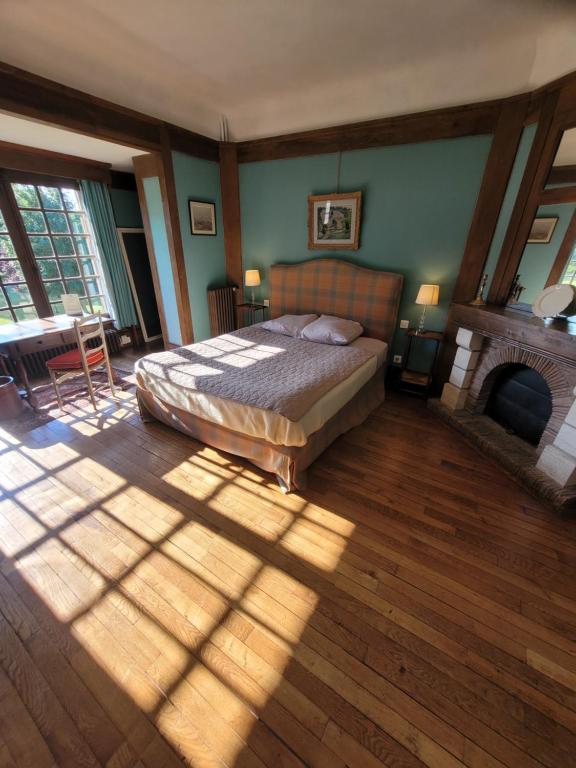 莱斯卡珀利斯博尔波Chambres d'Hôtes Manoir de Beaumarchais的带壁炉的客房内的一间卧室配有一张床