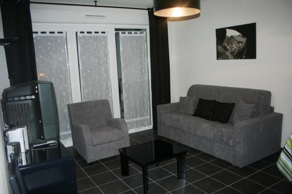康博莱班小说公寓的客厅配有沙发、椅子和电视