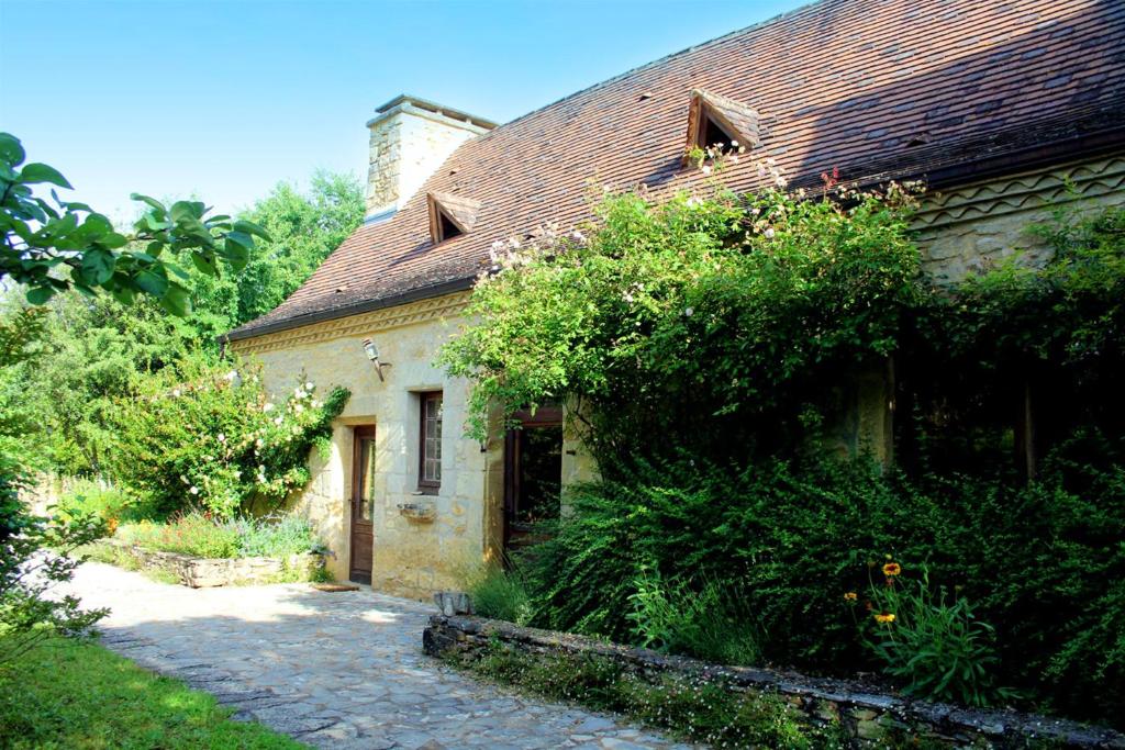 Saint-CybranetMaison de 4 chambres avec piscine partagee et jardin amenage a Saint Cybranet的一座古老的石头房子,外面有砖砌的走道