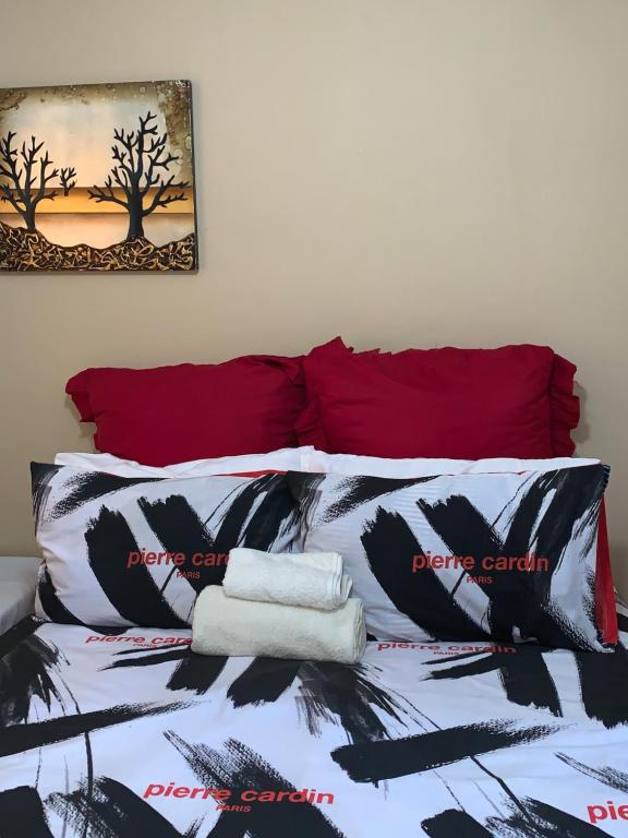 NewlandsStonebass Lodge的一张配有黑白床单和红色枕头的床