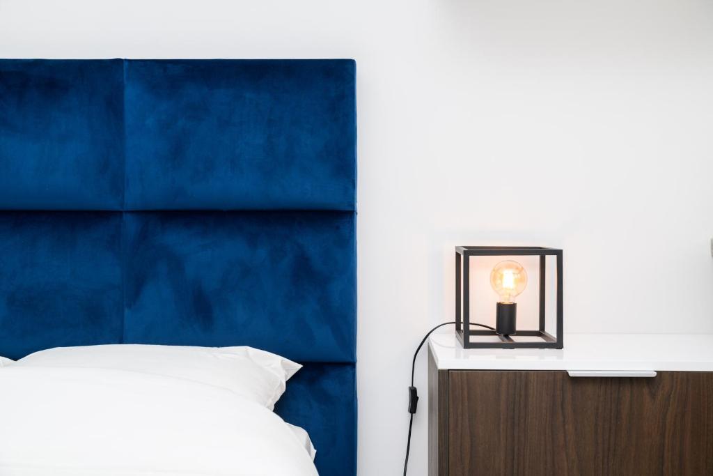 克雷泰伊The City Nest - Duke Housing的一间卧室配有一张床和一个蓝色床头板