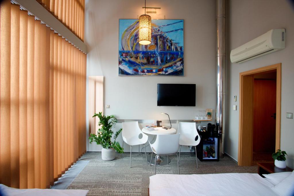尼萨河畔亚布洛内茨贾布朗尼公寓式酒店的卧室配有一张床和一张桌子及椅子