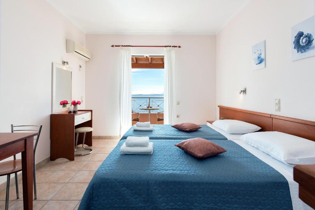 巴尔巴蒂Corfu Shell Apartments的一间卧室设有两张床、一张桌子和一个窗口。