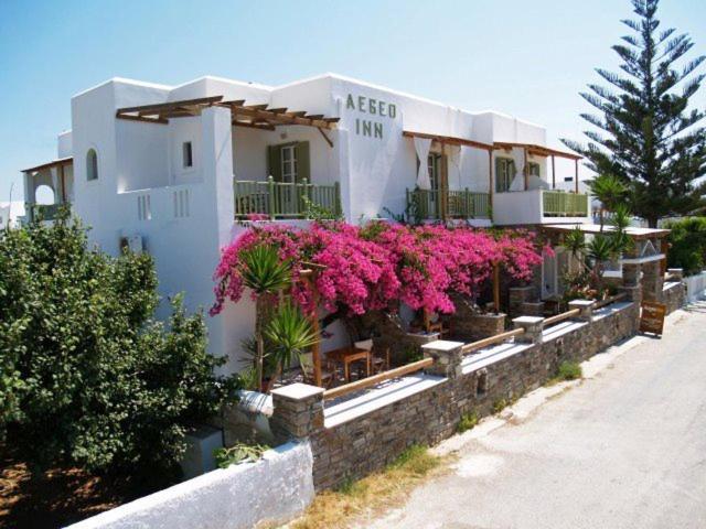 安迪帕罗斯岛Aegeo Inn的前面有粉红色花的建筑