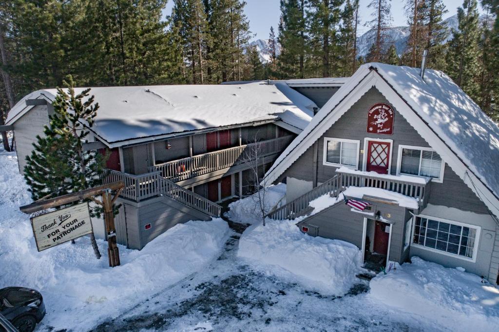 马姆莫斯湖红棕熊旅馆的雪覆盖的房子,前面有标志