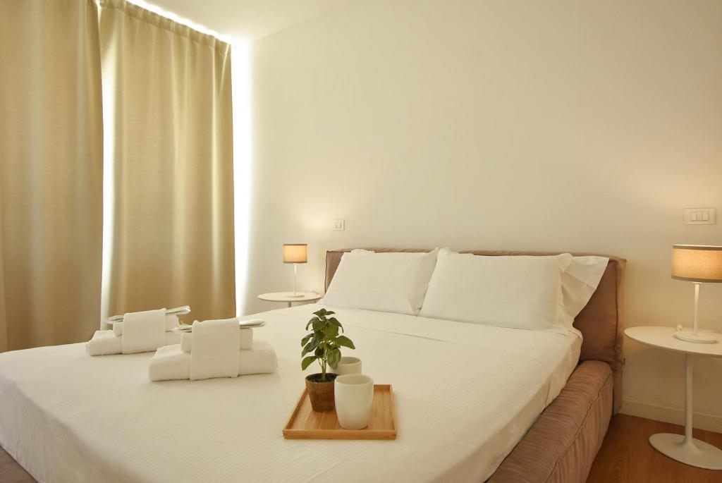 帕多瓦Luxury Battisti的卧室配有白色的床,上面有植物