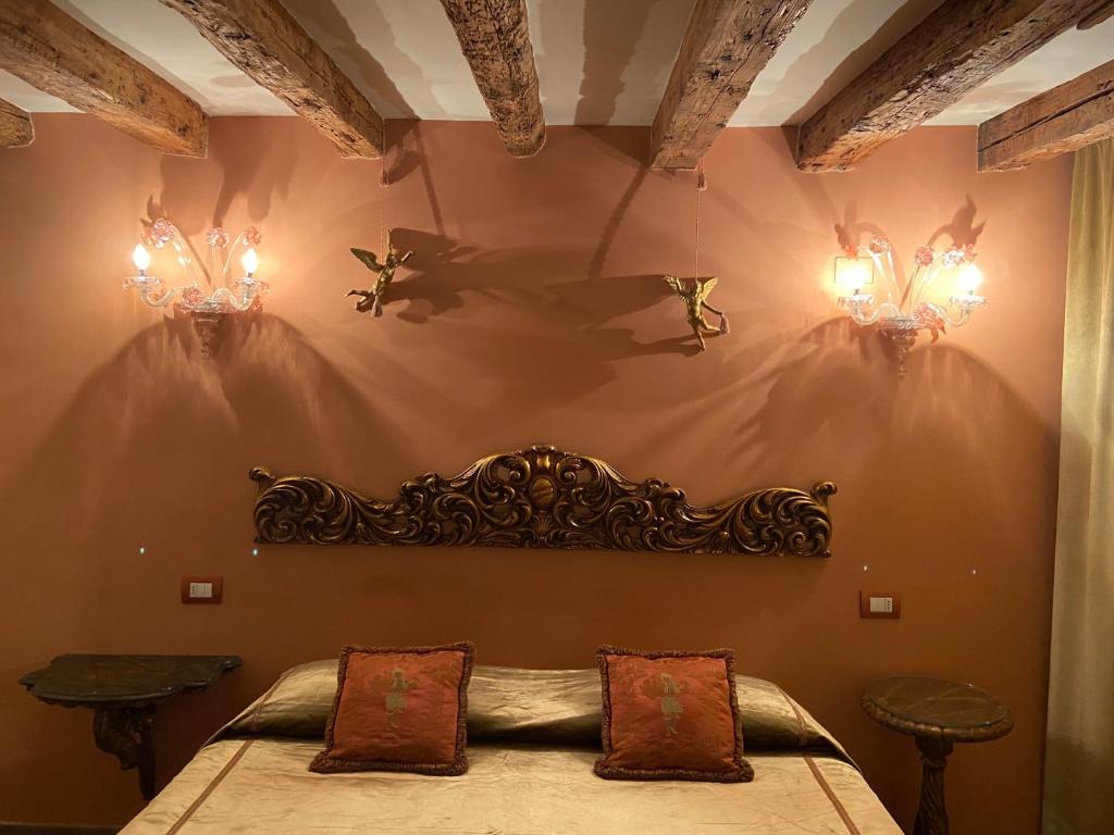威尼斯CA' DE' KOCAI的卧室配有一张带两盏灯的墙壁床。