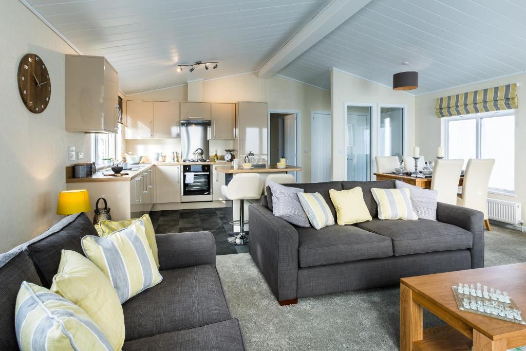 金斯林King's Lynn Caravan & Camping Park的一间带两张沙发的客厅和一间厨房