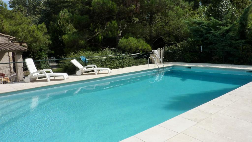 埃加利埃Mas Grimaud - Gîte- Studio et chambres d'hôtes familiales的一个带2把躺椅的游泳池和一个游泳池