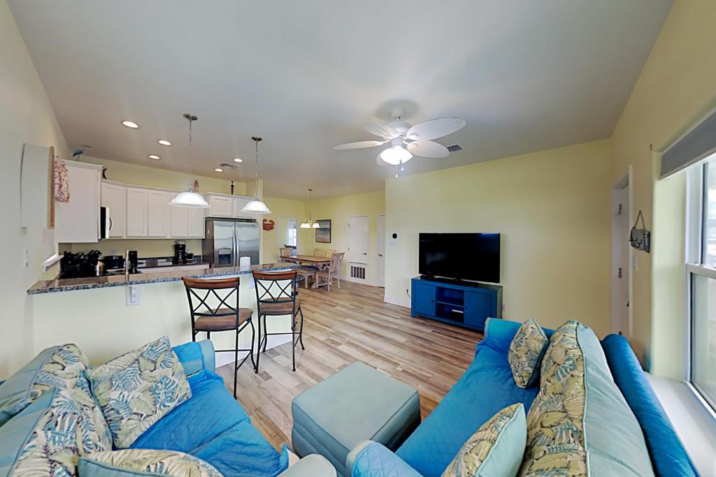 阿兰瑟斯港Flip Flop and Relax的一间带蓝色沙发的客厅和一间厨房