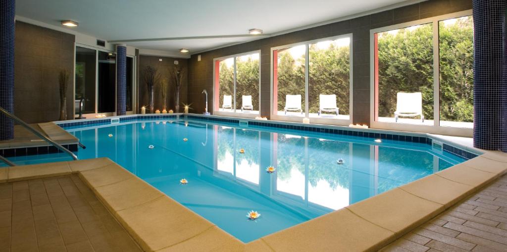 波里奥特米圣马蒂诺酒店的一座大型游泳池,位于一座带窗户的建筑内