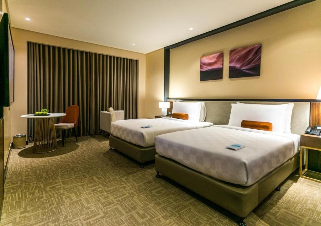 桑托斯将军城Grand Summit Hotel General Santos的酒店客房设有两张床和一张桌子。