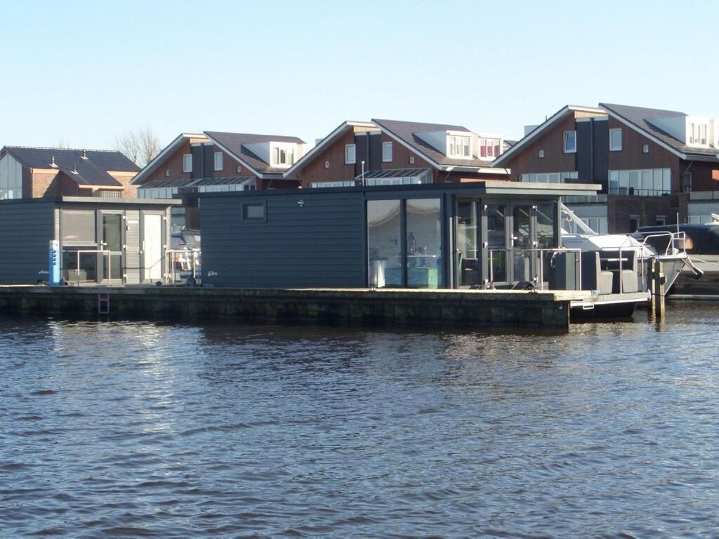 厄伊特海斯特Modern houseboat with air conditioning located in marina的水边码头上的房屋
