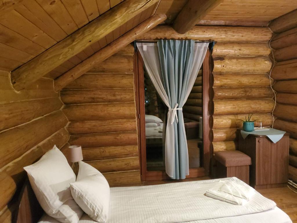 博尔塞克Papa la Șoni Gastro-Pensiune的小木屋内的卧室,配有床和窗户