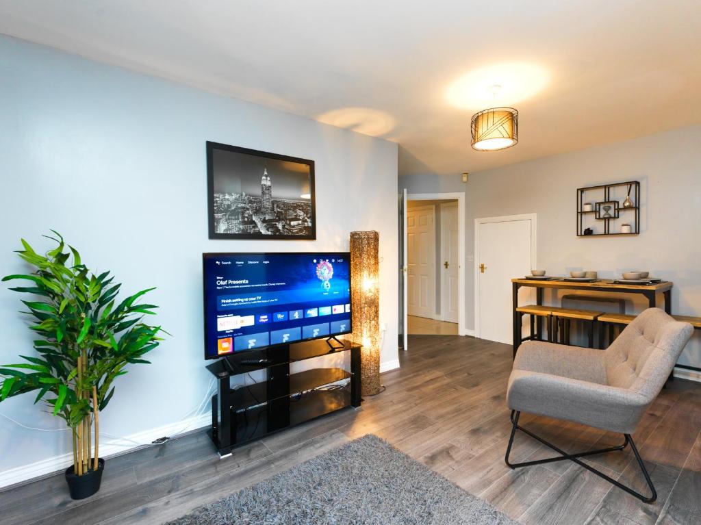 特尔福德Rothwell Close Serviced Two Bed Apartment的客厅配有平面电视和椅子。
