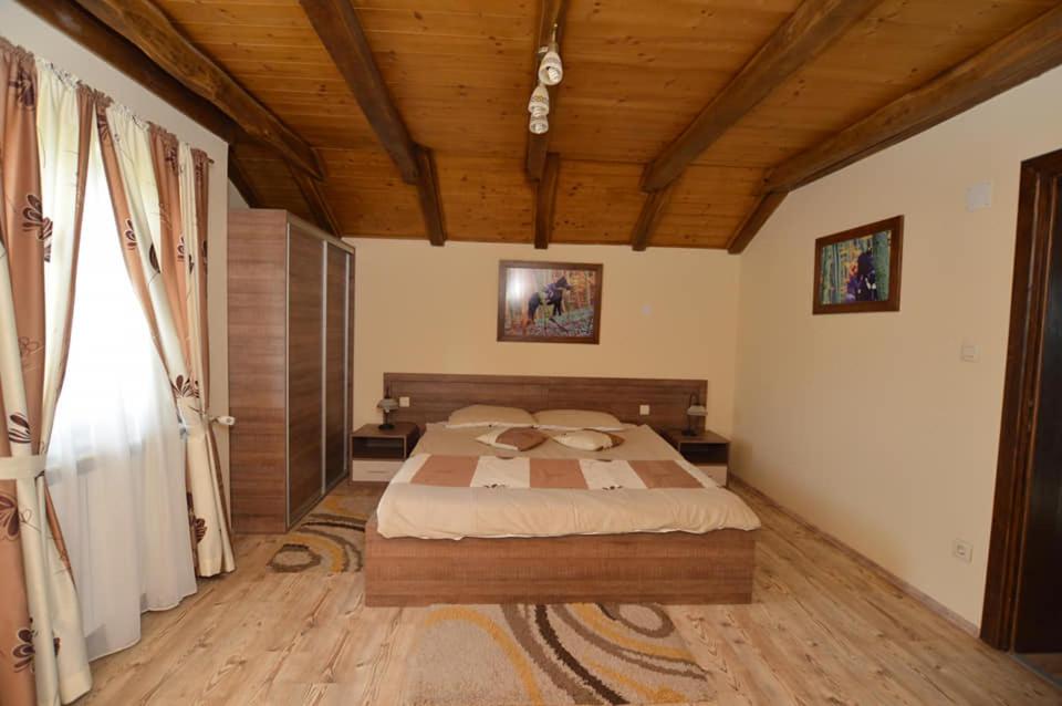 别洛瓦尔Rooms & Apartment Vinia的一间卧室设有一张大床和木制天花板
