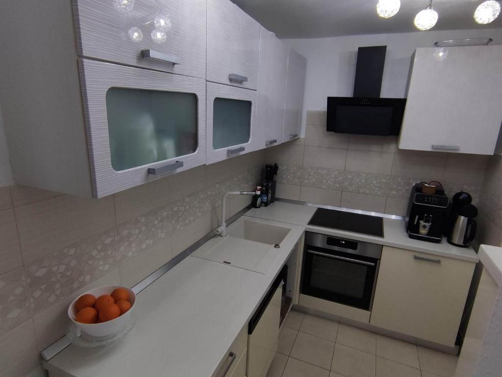 萨格勒布Apartment Roki的厨房配有白色橱柜和碗橘子柜台
