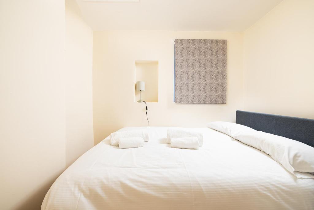伦敦Charmstay King's Cross的一张白色的床,上面有两个白色的枕头