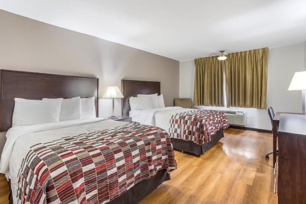 梅里迪恩Red Roof Inn Meridian的酒店客房设有两张床和窗户。