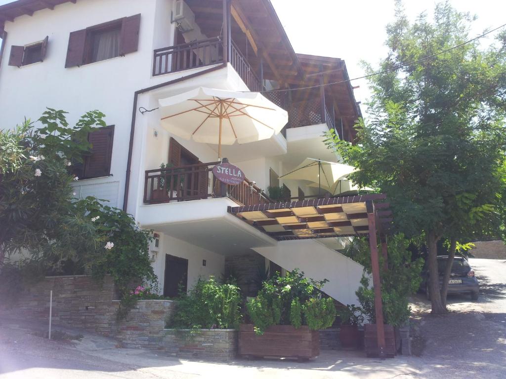 阿莫利亚尼岛Stella Maisonettes的带阳台和遮阳伞的白色建筑
