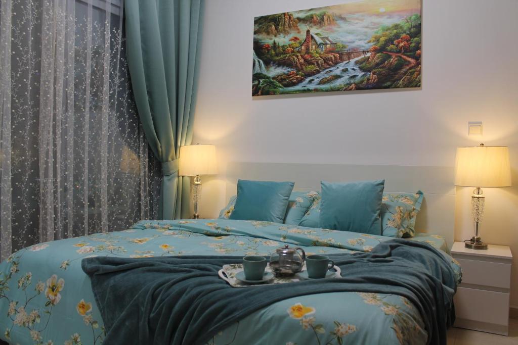 迪拜Newly furnished One Bedroom Apartment next to Metro & Beach in Marina Residence的一间卧室配有一张床,上面放着一个食物托盘