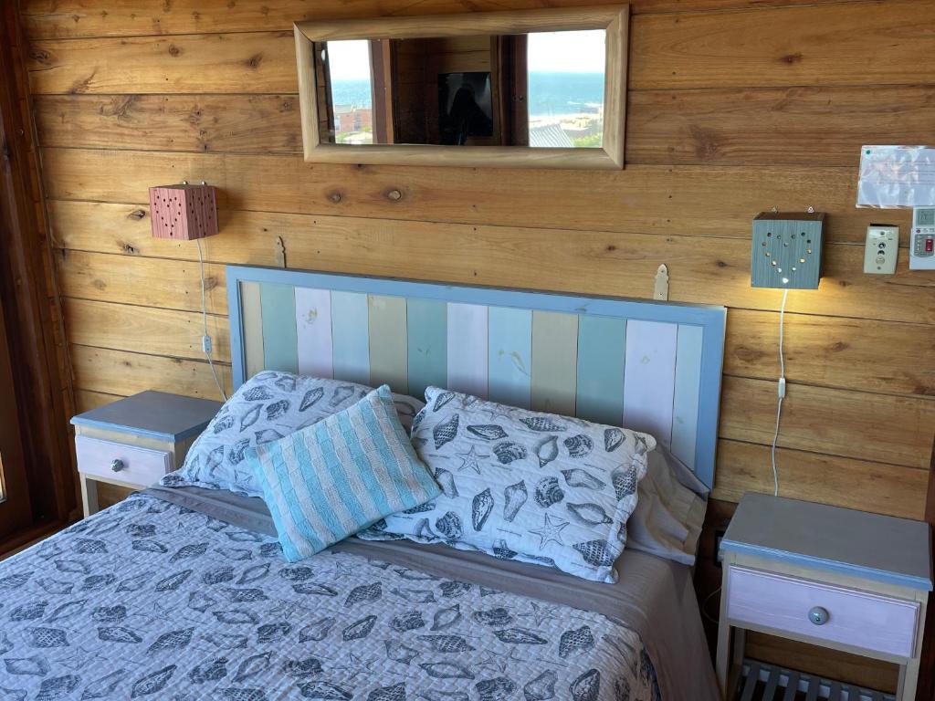 德尔迪阿布罗角四女孩山林小屋的一间卧室配有一张带2个床头柜和镜子的床