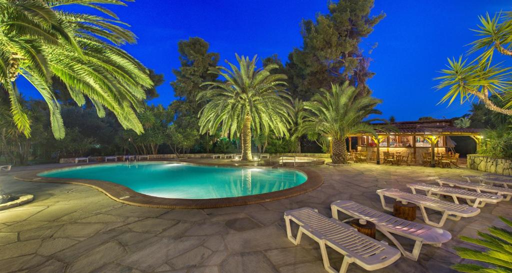 佩科霍里皮拉里迪斯酒店的一个带躺椅和棕榈树的游泳池