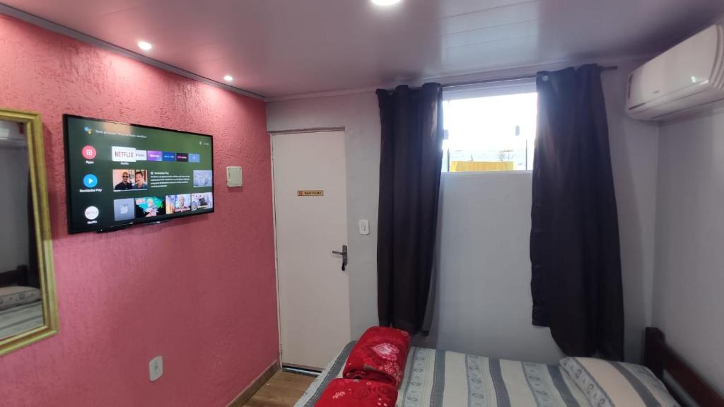 阿拉亚尔-杜卡布Space Hostel , quartos privativos的一间设有床铺和墙上电视的房间
