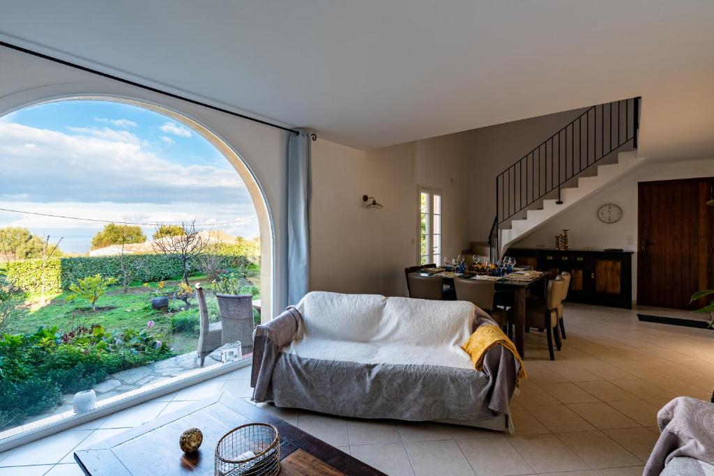 AregnoAria - Vue Mer的客厅设有大窗户和桌子