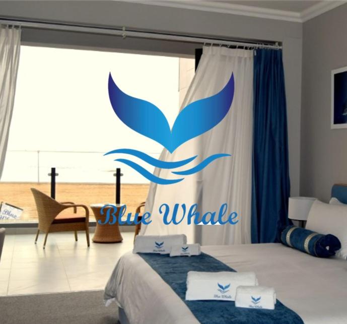 鲸湾港Blue Whale Hotels的卧室,床上有蓝鲸标志